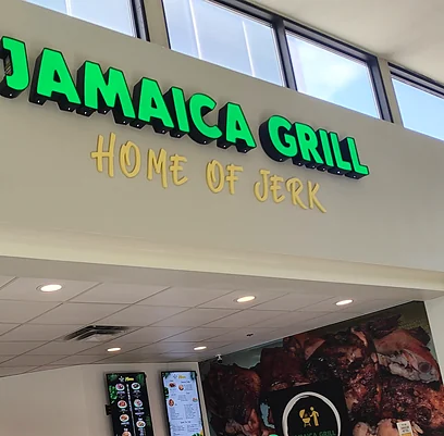 Jamaica Grill food court counter with its green Home of Jerk sign